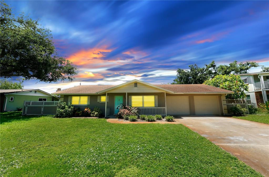 A single-story house with a two-car garage and a turquoise front door at sunset — 5211 24TH AVENUE DRIVE W, BRADENTON, FL