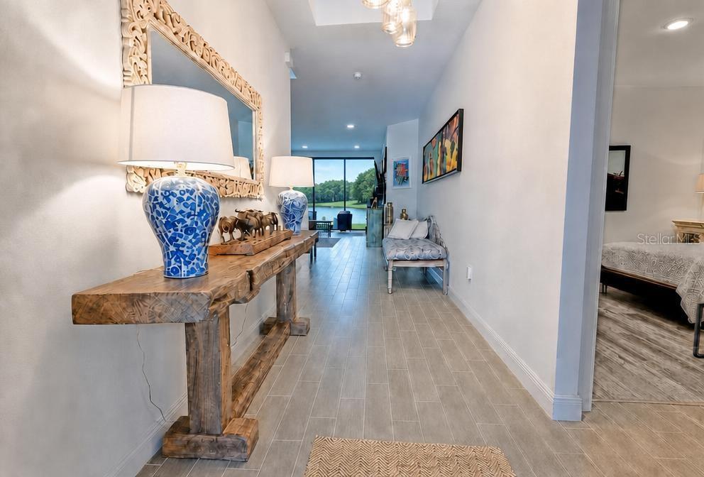 A hallway with a wooden console table, blue lamps, and a view of a lake — 17649 LIVE OAK DRIVE, TAVARES, FL