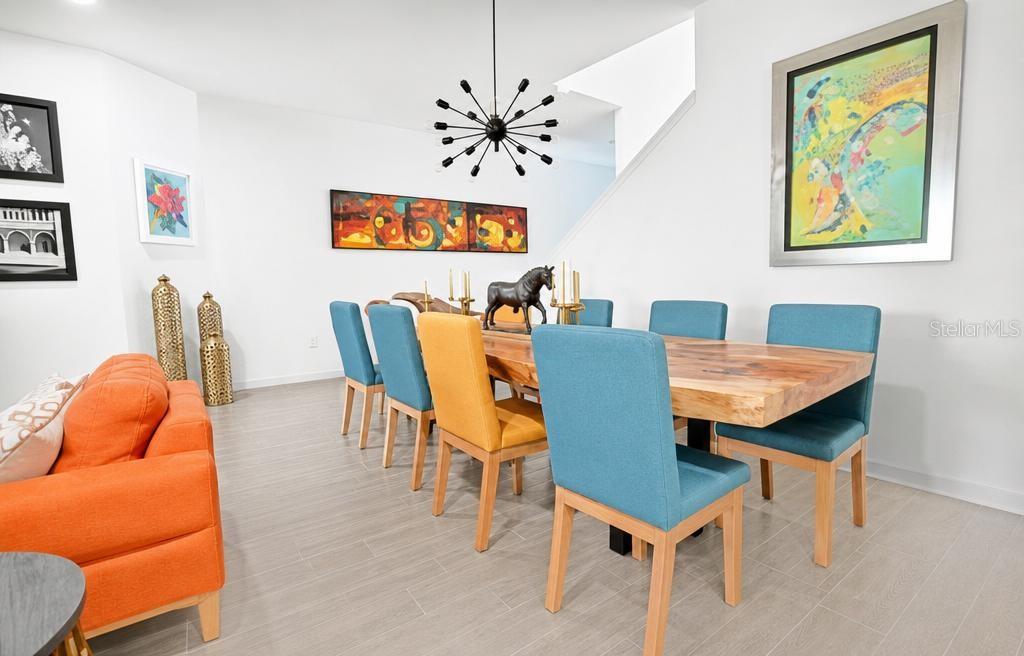A dining room features a live-edge wooden table, colorful chairs, and a modern sputnik chandelier — 17649 LIVE OAK DRIVE, TAVARES, FL