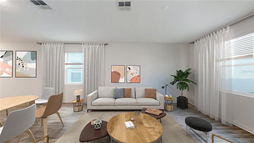 This is a digitally staged living room featuring a sofa, coffee table, and dining area — 5694 KETTLEBELL ALLEY, CLERMONT, FL
