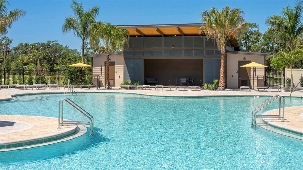 A swimming pool with metal handrails sits in front of a modern outdoor pavilion — 10650 HIDDEN BANKS GLEN, PARRISH, FL