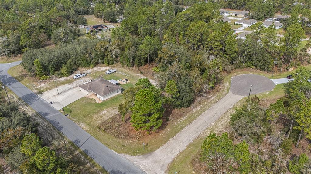 An aerial view shows a single-story house on a corner lot with surrounding wooded areas — 1541 W RILEY DRIVE, DUNNELLON, FL