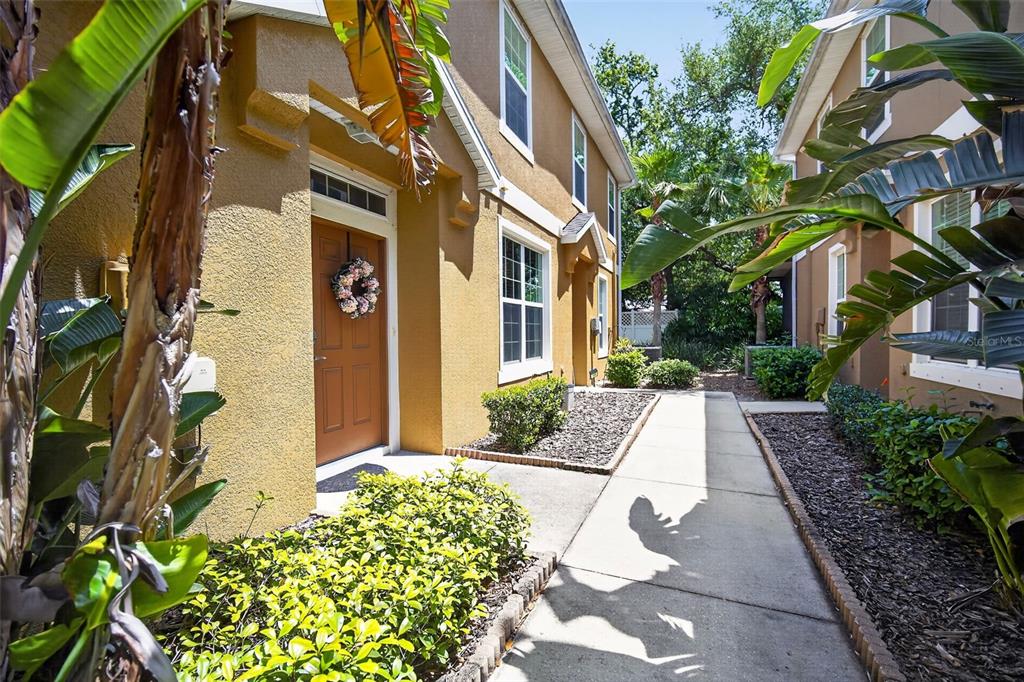 A tan two-story townhouse exterior with a brown front door and a concrete walkway — 7001 INTERBAY BOULEVARD UNIT 148, TAMPA, FL
