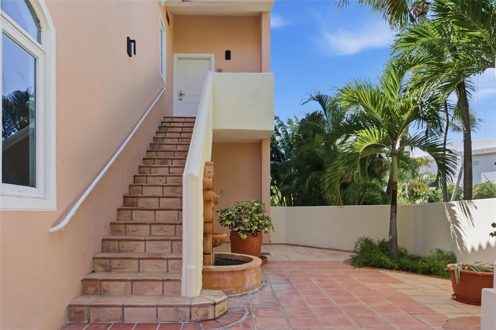 An exterior view of a peach-colored building with tiled stairs leading to an upper entrance — Las Casitas I 1000 AVENUE EL CONQUISTADOR UNIT 5241-42-43, FAJARDO, PR