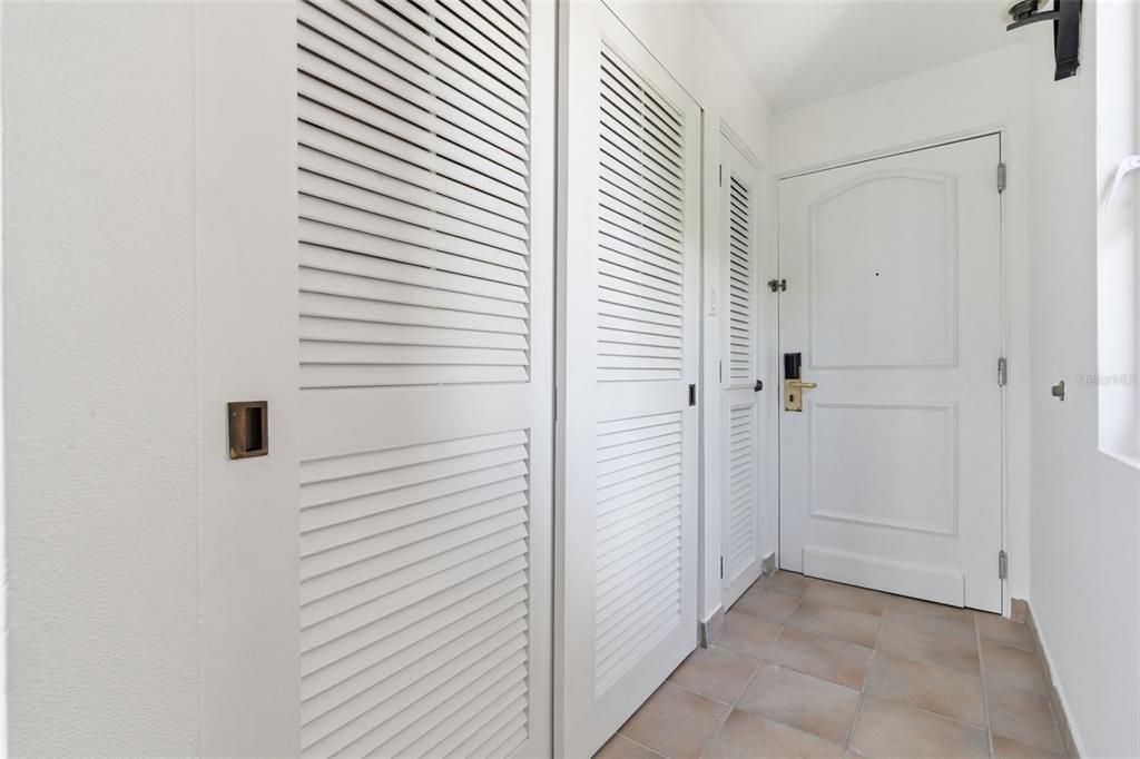A hallway features white louvered closet doors, a white entry door, and light-colored tile flooring — Las Casitas I 1000 AVENUE EL CONQUISTADOR UNIT 5241-42-43, FAJARDO, PR