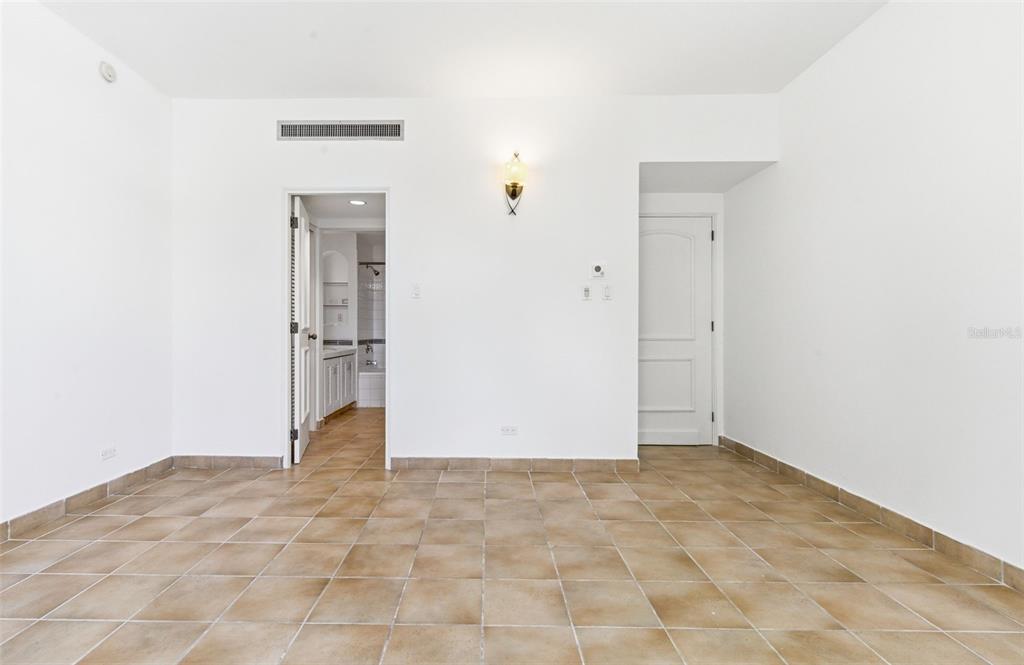 An empty room with tan tile flooring, white walls, and two interior doorways — Las Casitas I 1000 AVENUE EL CONQUISTADOR UNIT 5241-42-43, FAJARDO, PR