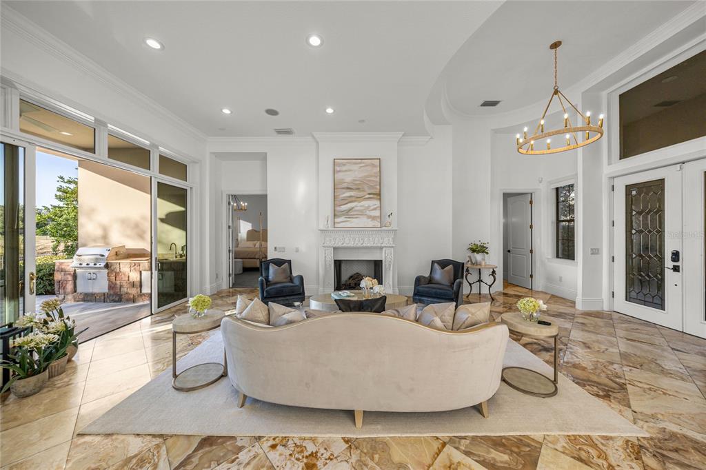 A bright living room features a fireplace, tile flooring, and sliding doors opening to a patio — 2730 NW 80TH AVENUE, OCALA, FL