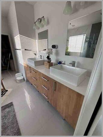 A bathroom features a double vanity with wood cabinets, white vessel sinks, and two mirrors — 857 Wandering Willow Way, FL 33470, FL