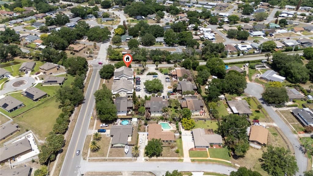 This aerial view shows a multi-unit residential complex with a parking lot and swimming pools — 2613 S PARK AVENUE, TITUSVILLE, FL