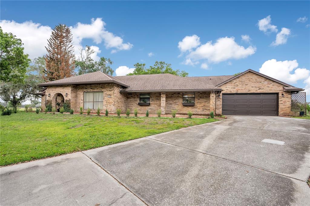 A single-story brick house features a brown shingled roof, a garage, and a front lawn — 2724 ARDON AVENUE, ORLANDO, FL