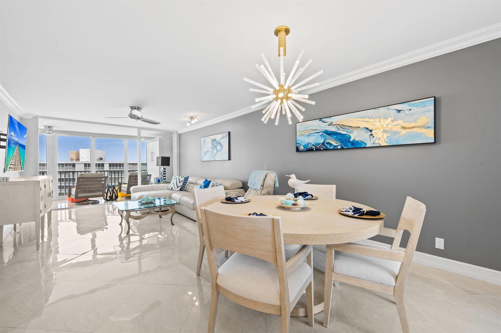 A dining area and living room with light tile floors, gray walls, and a modern chandelier — 3300 S Ocean Boulevard # 1020, Highland Beach FL 33487, HIGHLAND BEACH, FL