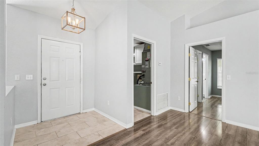 A foyer with tile flooring, a light fixture, and two doorways leading to other rooms — 56 HEMLOCK RADIAL, OCALA, FL