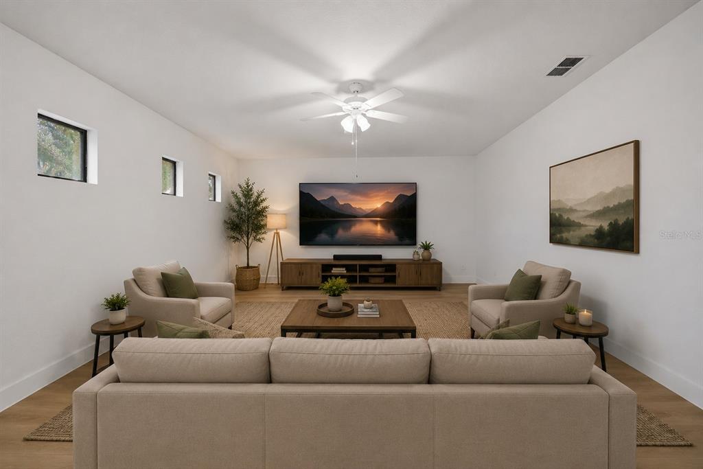 A living room features a sofa, two armchairs, a coffee table, and a wall-mounted television — 1908 ABBEY RIDGE DRIVE, DOVER, FL