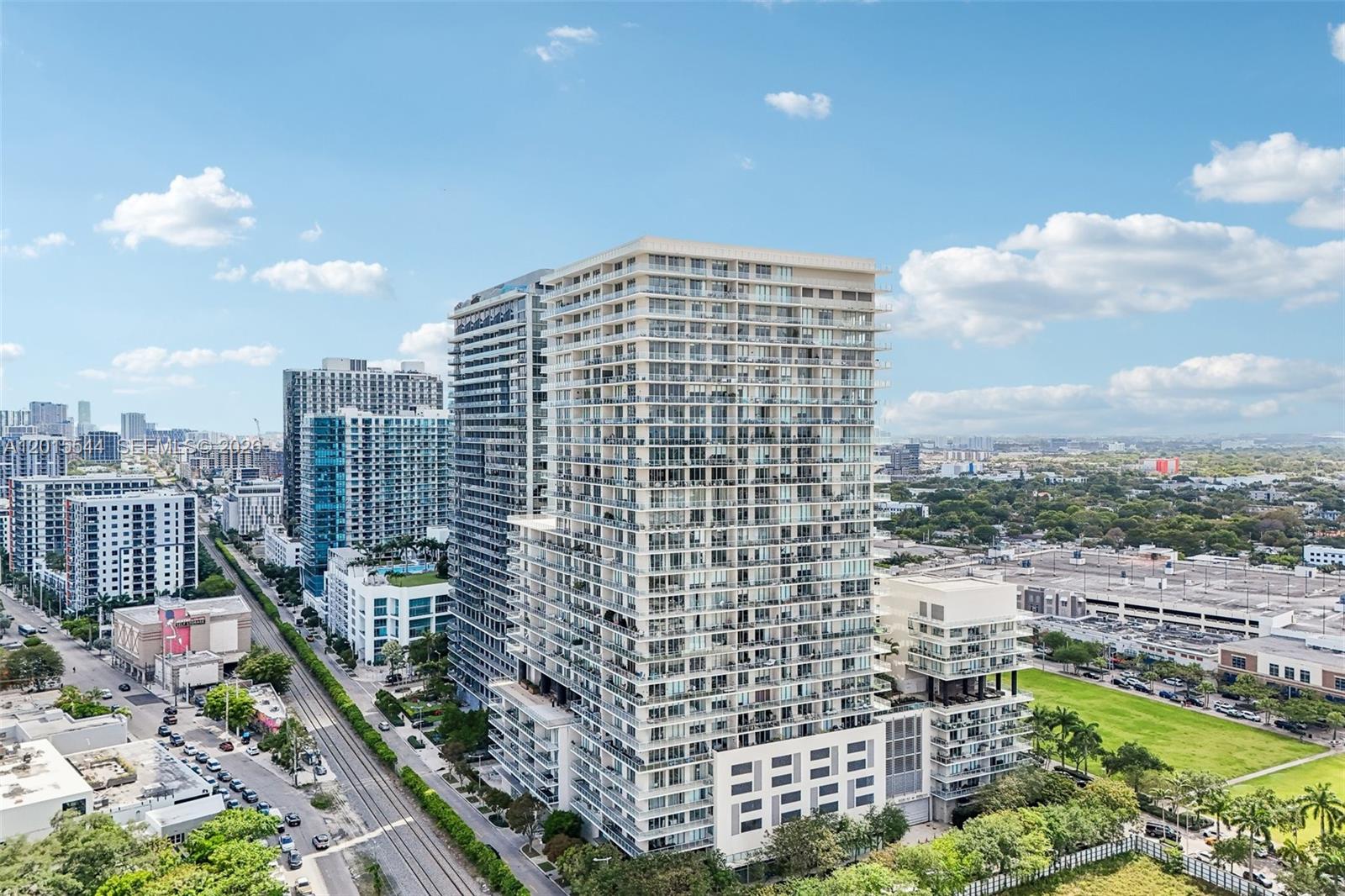 An aerial view shows a tall residential high-rise building surrounded by city streets and greenery — 3470 E Coast Ave # H2503, Miami FL 33137, MIAMI, FL