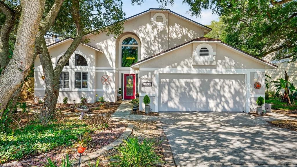 A two-story house with a beige stucco exterior, a red front door, and a garage — 4758 S PENINSULA DRIVE, PONCE INLET, FL