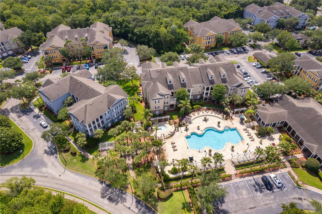 An aerial view shows apartment buildings surrounding a central swimming pool and parking lots — 3589 CONROY ROAD UNIT 1015, ORLANDO, FL