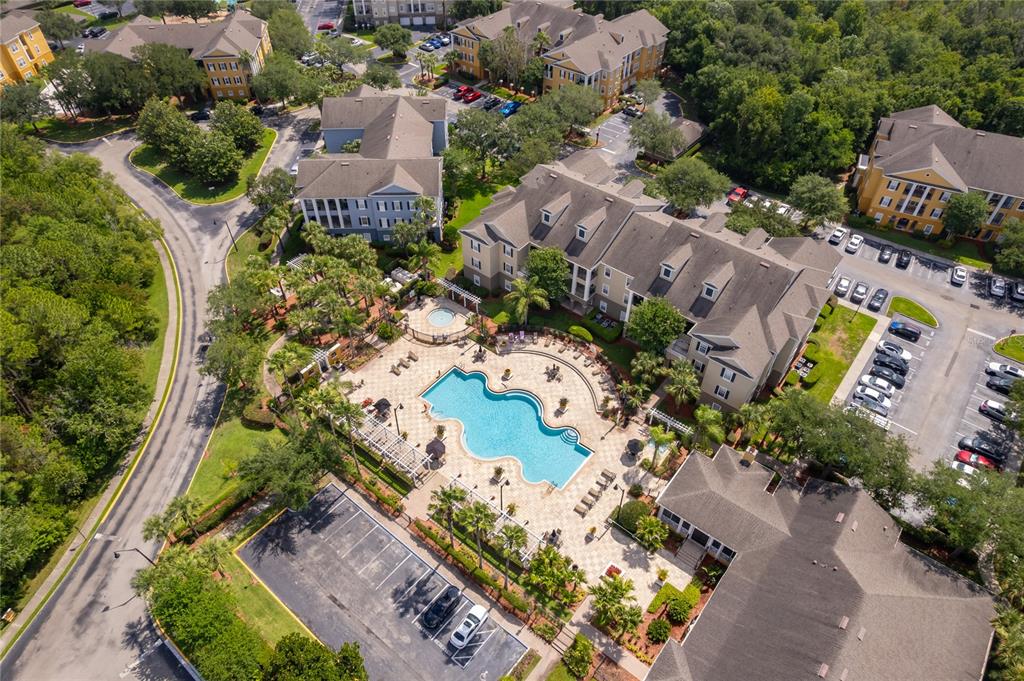 An aerial view of an apartment complex featuring a central swimming pool and parking lots — 3589 CONROY ROAD UNIT 1015, ORLANDO, FL