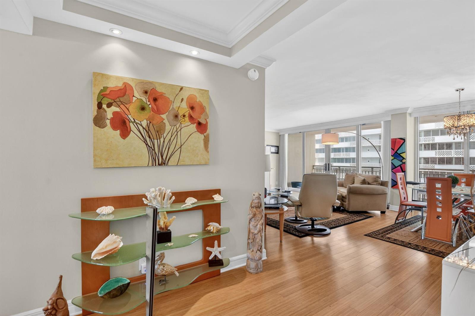 A living and dining area features hardwood floors, a glass display shelf, and large windows — 1180 S Ocean Boulevard # 0055, Boca Raton FL 33432, BOCA RATON, FL