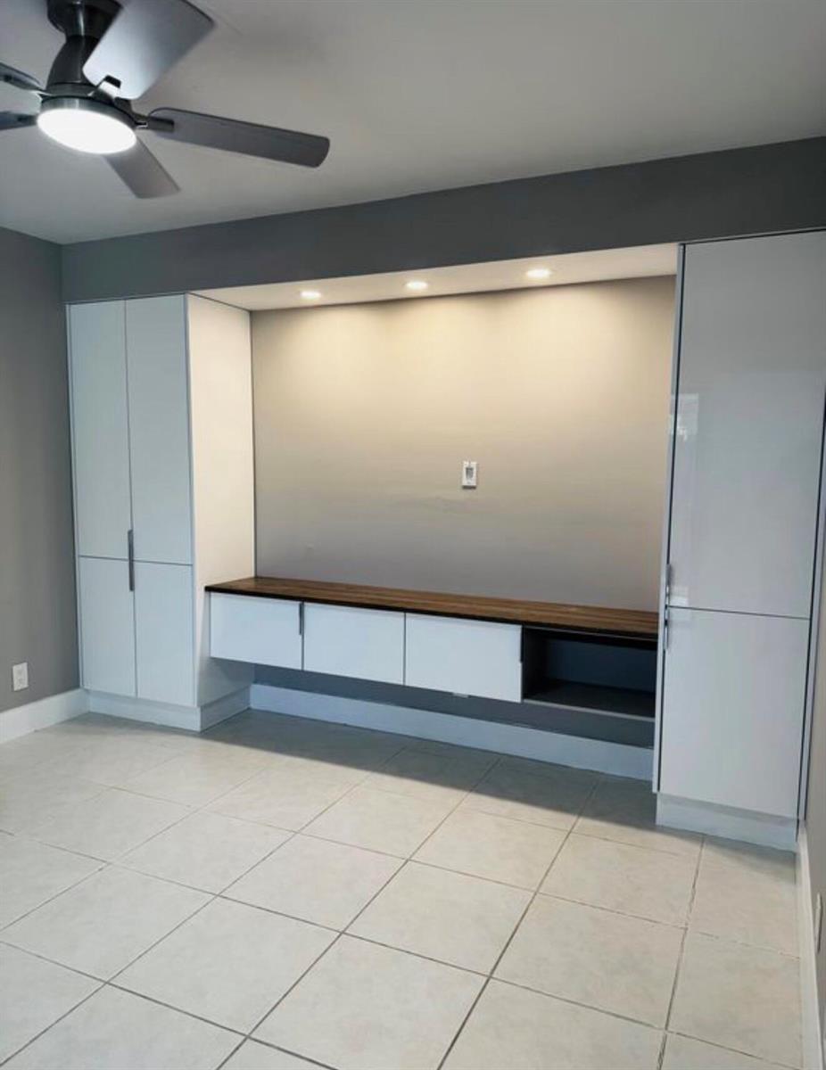 A room features a built-in white entertainment center with a dark wood countertop and cabinets — 3665 Silver Lace Ln # 77, Boynton Beach FL 33436, BOYNTON BEACH, FL