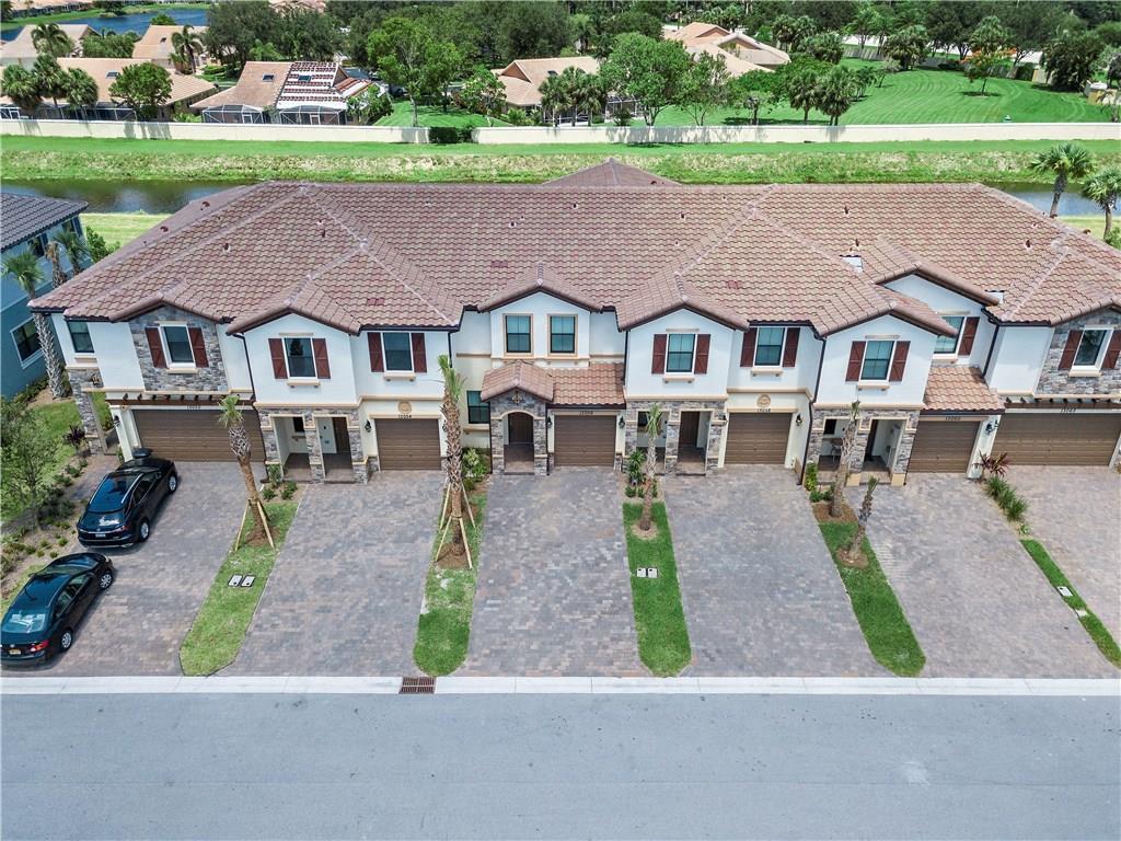 An aerial view of a multi-unit townhouse complex with paved driveways and a tiled roof — 13056 Anthorne Lane # 113, Boynton Beach FL 33436, BOYNTON BEACH, FL