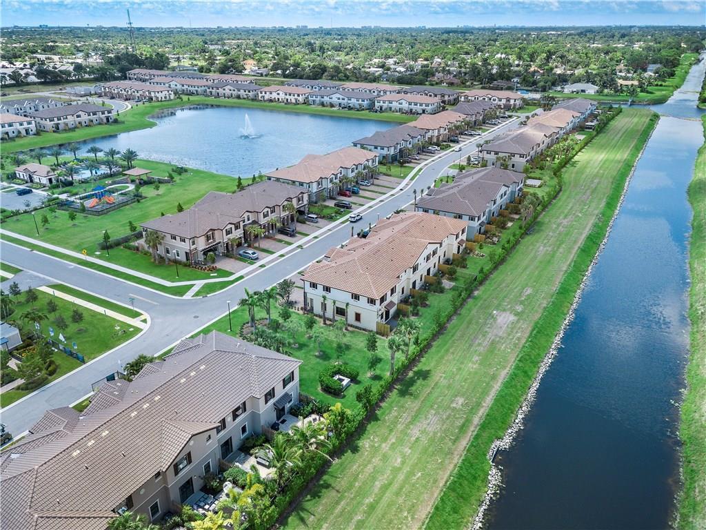 An aerial view shows a residential community with townhouses, a lake, and a canal — 13056 Anthorne Lane # 113, Boynton Beach FL 33436, BOYNTON BEACH, FL