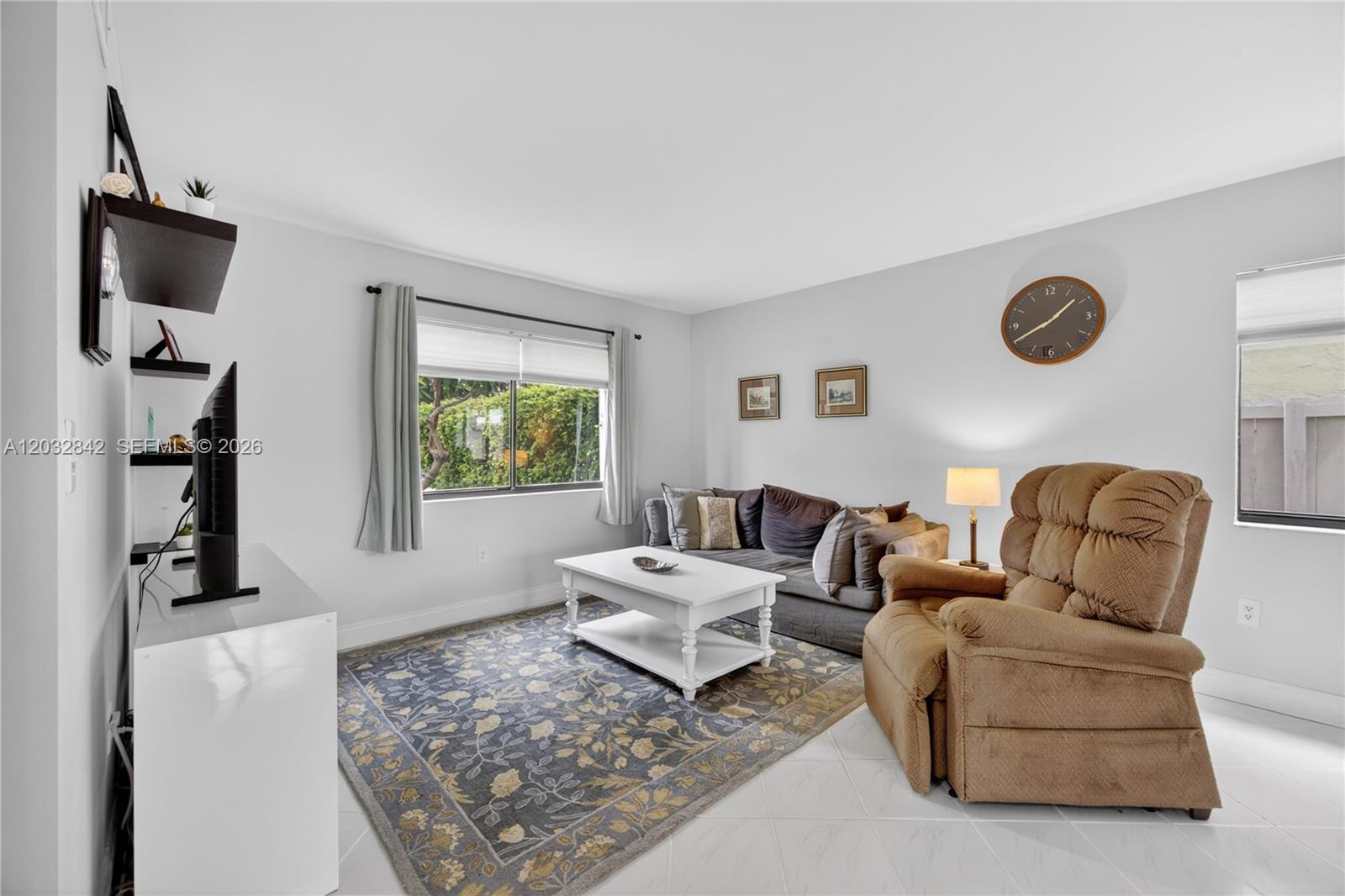 A living room features a brown recliner, a gray sofa, a white coffee table, and tile flooring — 8210 SW 96th Ct, Miami FL 33173, MIAMI, FL