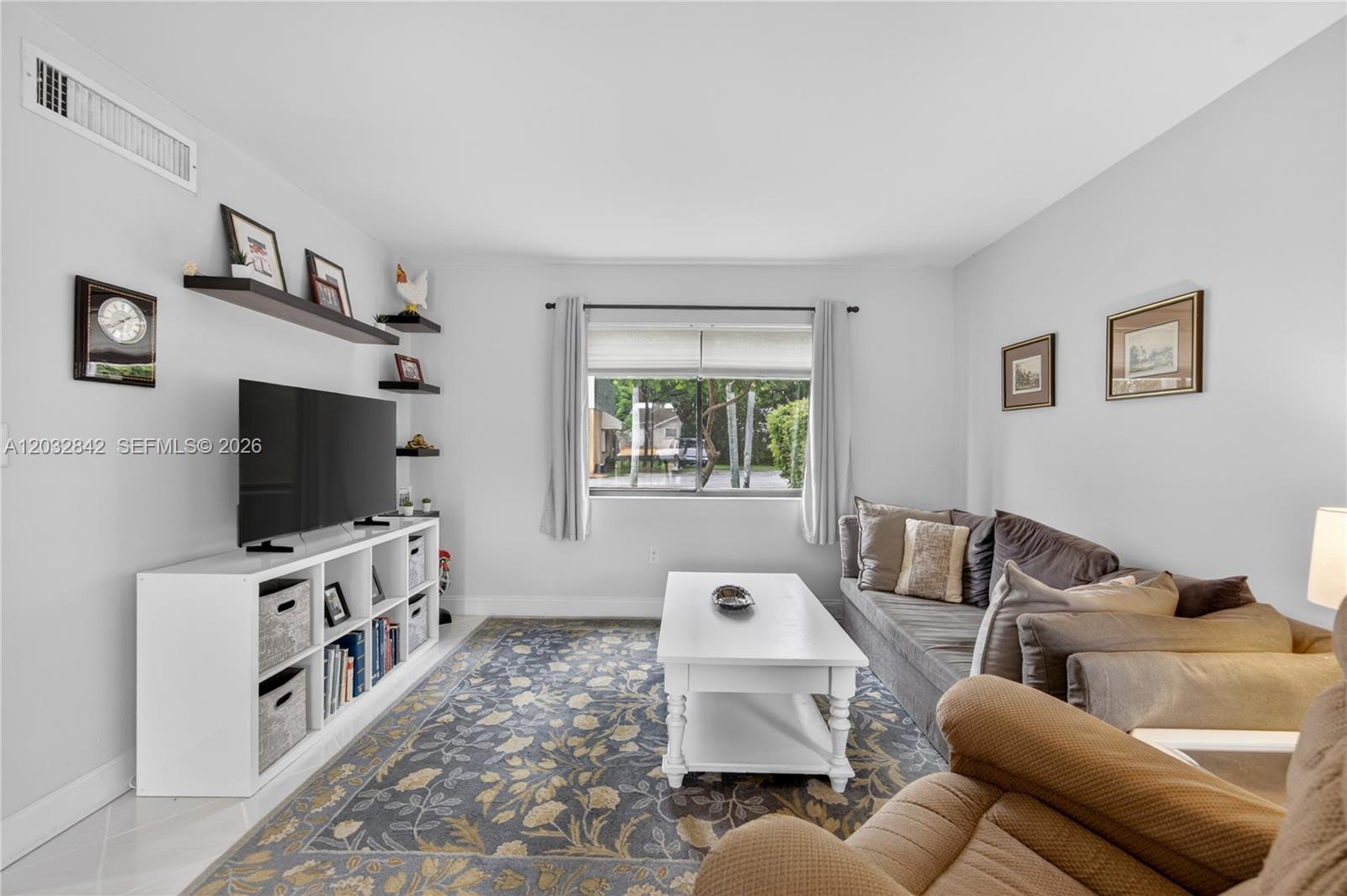 A living room features a white media console, a patterned rug, and a gray sofa — 8210 SW 96th Ct, Miami FL 33173, MIAMI, FL