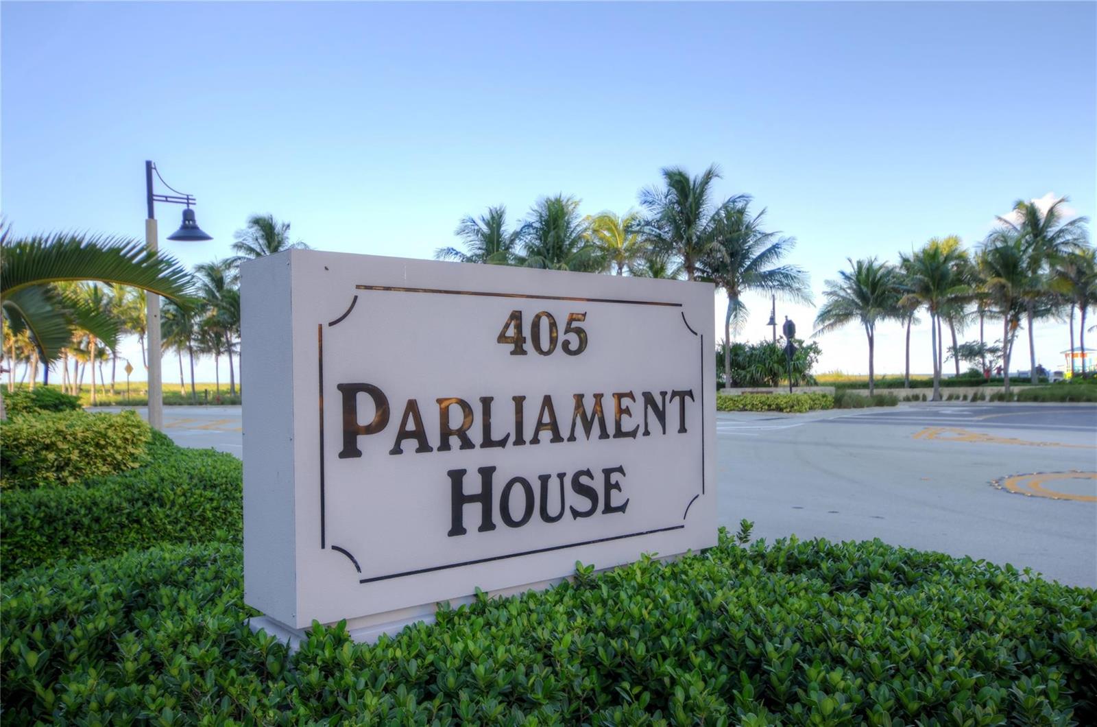 A white sign reading 405 Parliament House stands in front of palm trees and pavement — 405 N Ocean Boulevard # 207, Pompano Beach FL 33062, POMPANO BEACH, FL