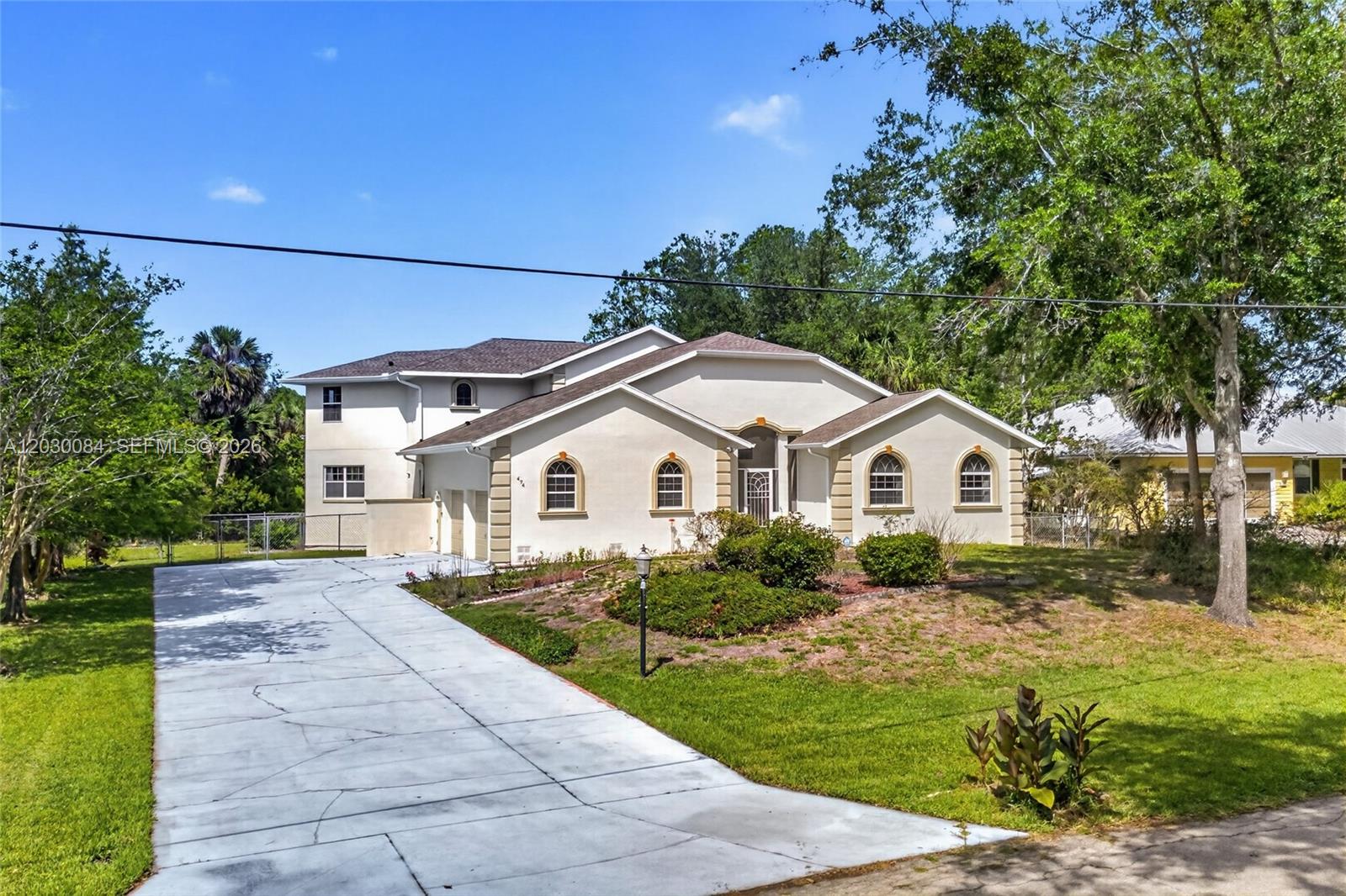 A two-story stucco house with a concrete driveway and arched windows sits on a lawn — 474 N Afterglow Circle, Crystal River FL 34429, CRYSTAL RIVER, FL
