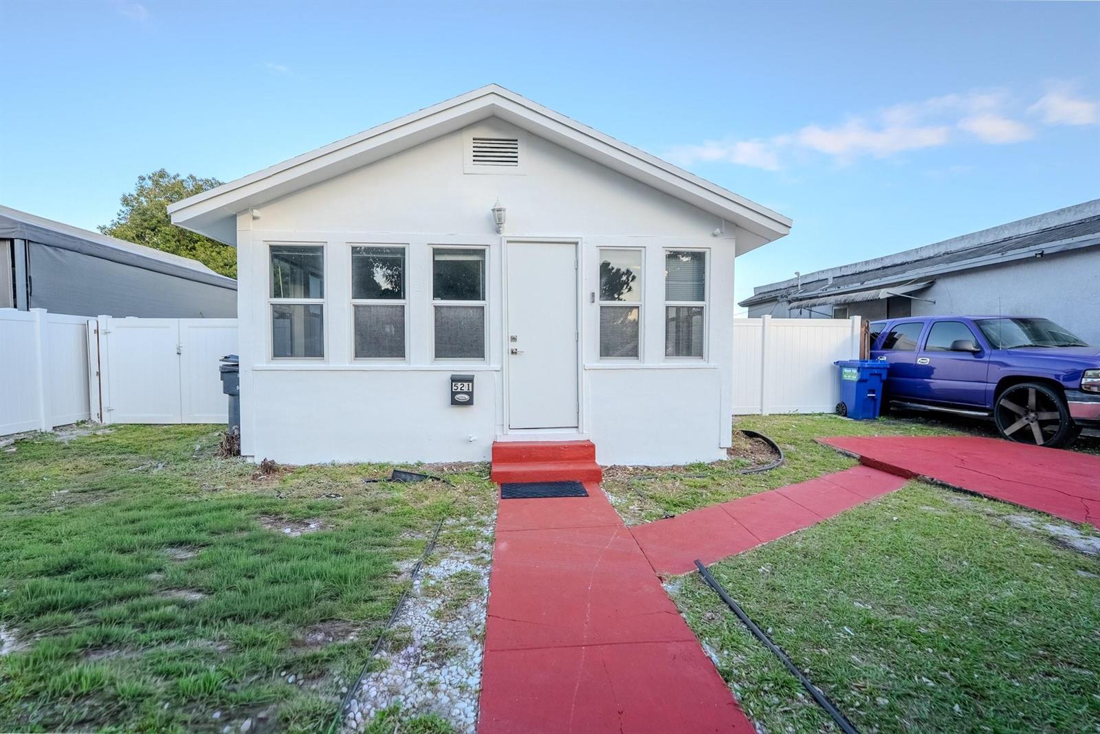 A white house with a red walkway and steps sits on a grassy lot — 521 S 24th Avenue, Hollywood FL 33020, HOLLYWOOD, FL
