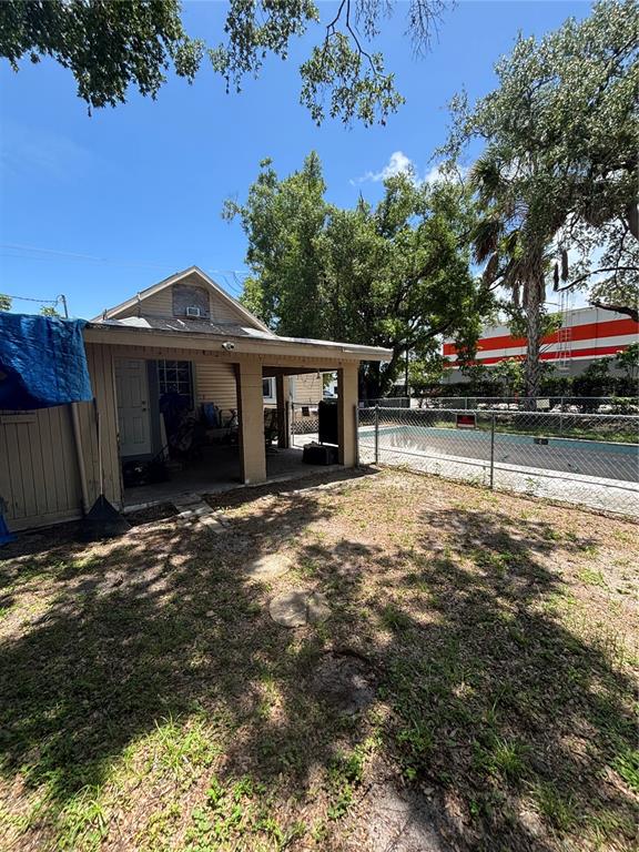 A backyard features a covered patio attached to a small house next to a pool — 1906 HANSON STREET, FORT MYERS, FL
