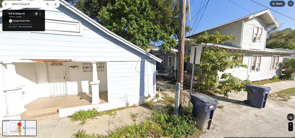 The exterior view shows two light-colored houses with a utility pole and trash bins — 2806 N TAMPA STREET, TAMPA, FL