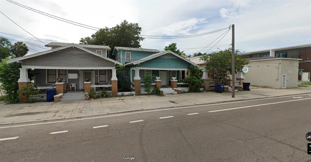 Three adjacent single-story houses with front porches sit along a paved street — 2806 N TAMPA STREET, TAMPA, FL
