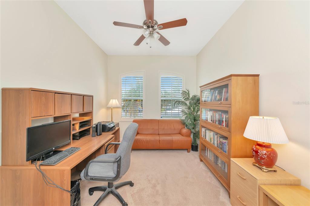 A home office features a desk, a leather sofa, a bookshelf, and two windows — 13412 22ND COURT E, PARRISH, FL