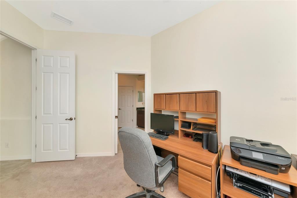 A home office features a wooden desk with a hutch, a gray chair, and a printer — 13412 22ND COURT E, PARRISH, FL