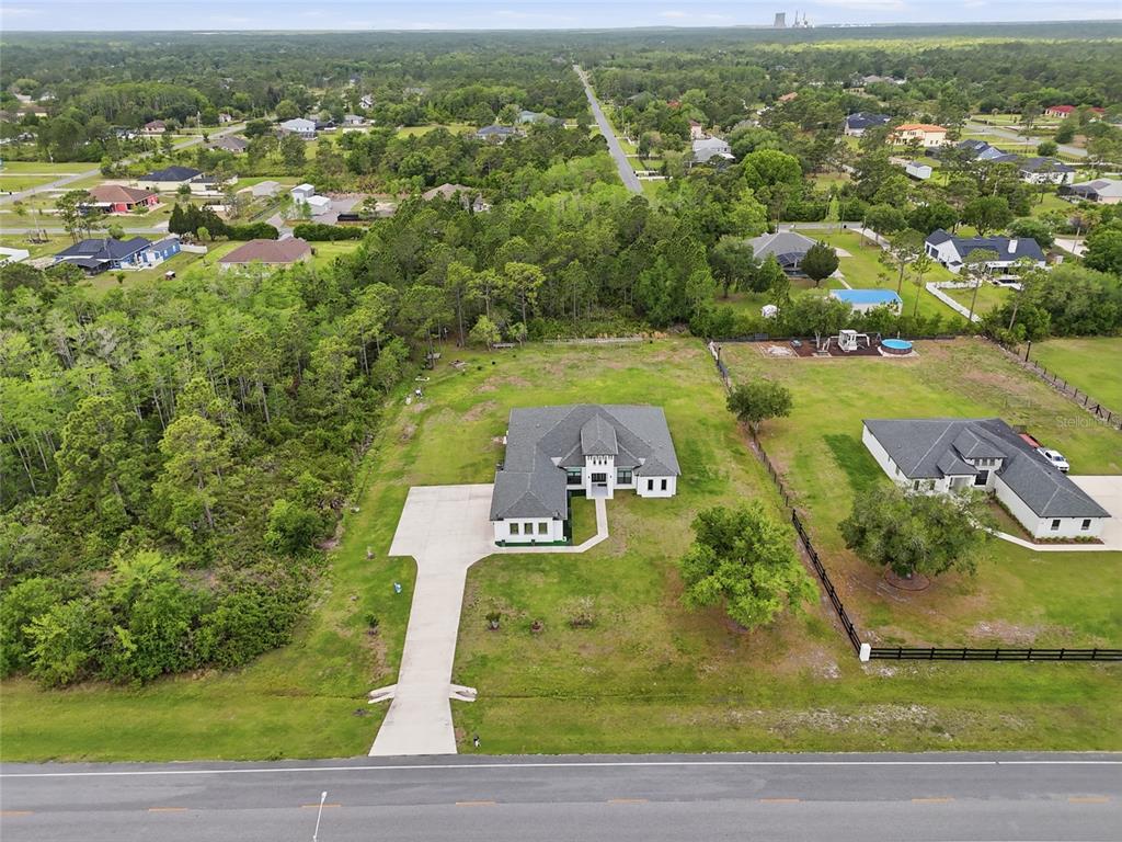 An aerial view shows a single-story house with a concrete driveway on a large lot — 5700 BANCROFT BOULEVARD, ORLANDO, FL