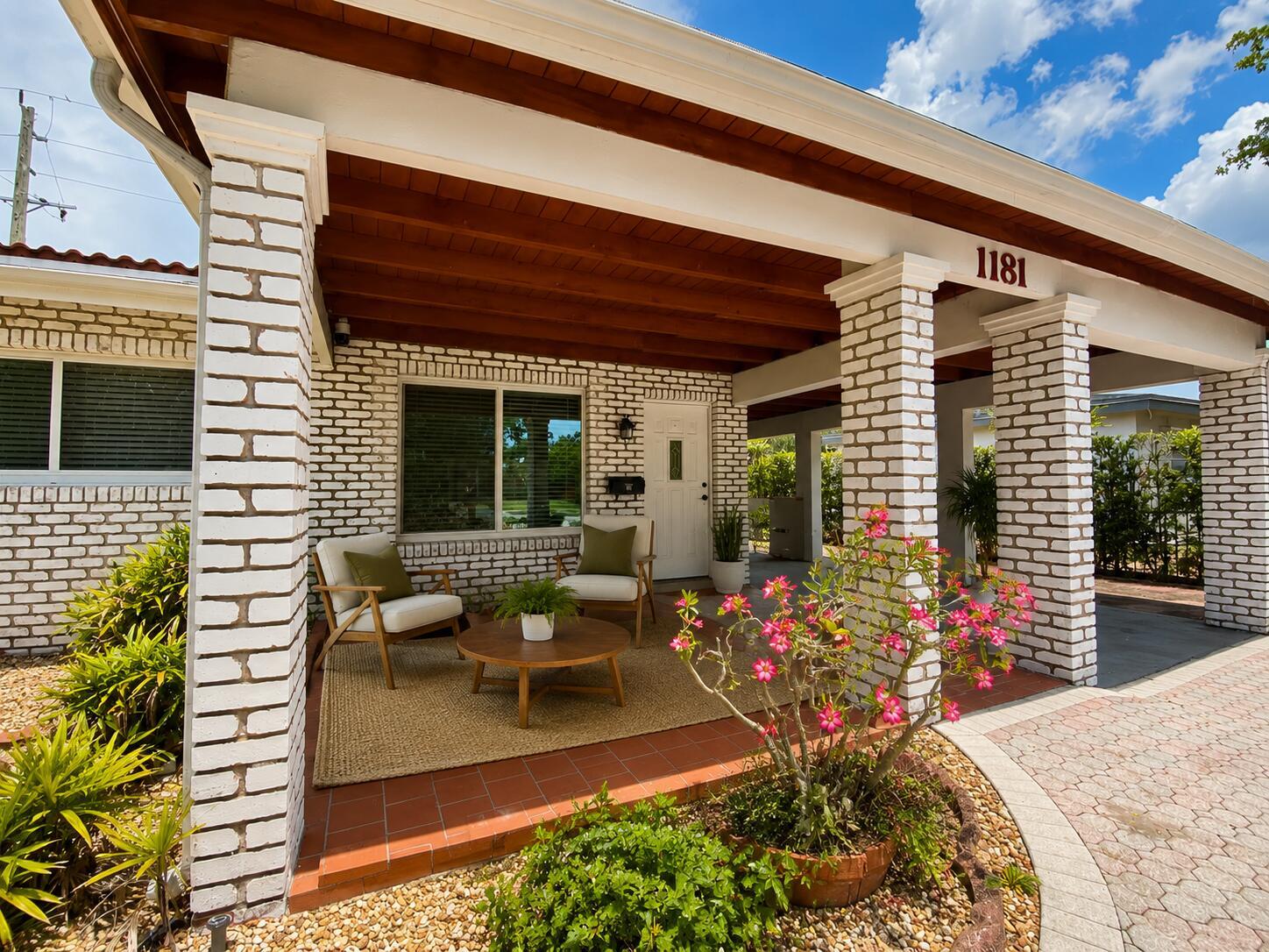 A covered front porch features white brick columns, a wood-plank ceiling, and two chairs — 1181 SW 4th Terrace, Pompano Beach FL 33060, POMPANO BEACH, FL