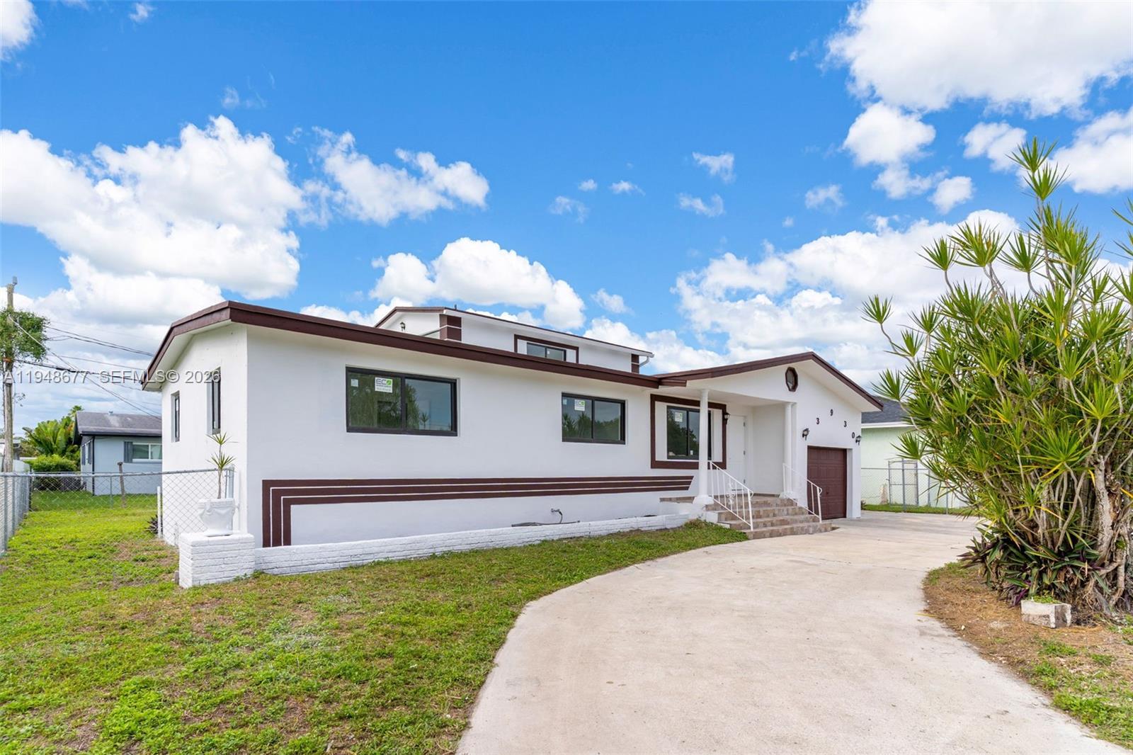 A white single-story house with brown trim and a concrete driveway under a blue sky — 13930 Van Buren St, Miami FL 33176, MIAMI, FL