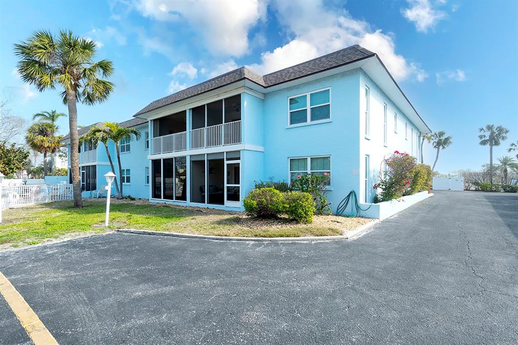 A two-story, light blue apartment building with screened balconies and a paved parking lot — 4307 GULF DRIVE UNIT 207, HOLMES BEACH, FL
