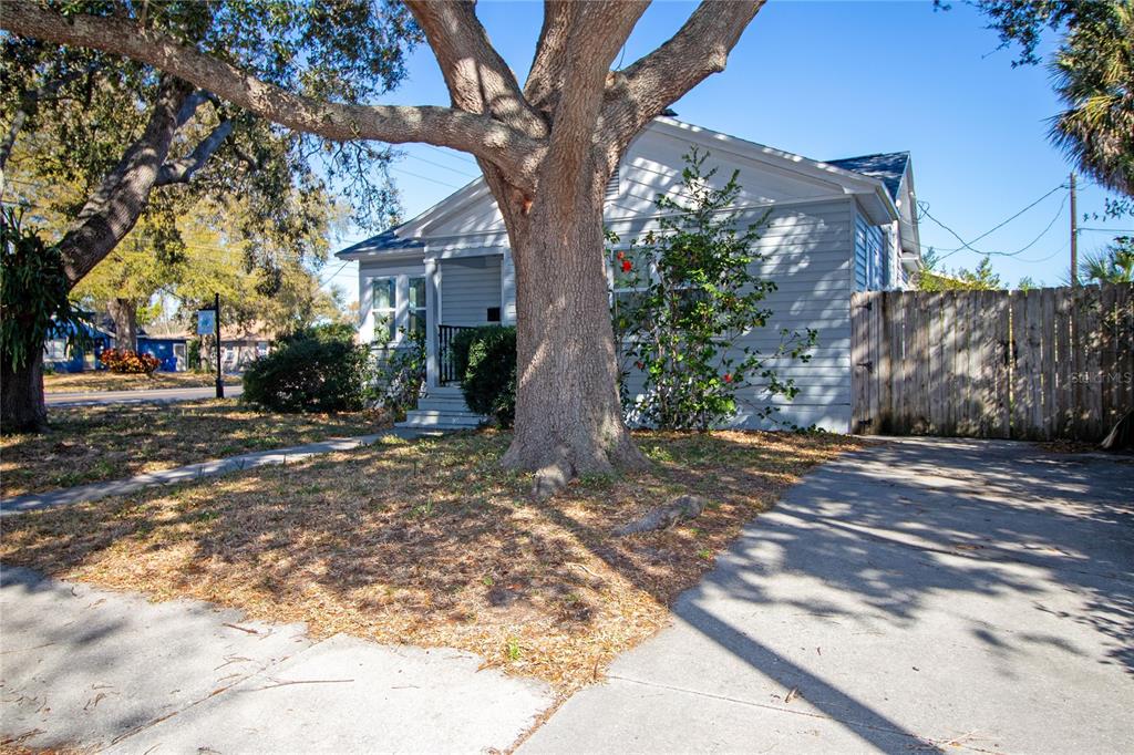 A light blue house with a large tree in the front yard and a driveway — 1547 35TH AVENUE N, ST PETERSBURG, FL