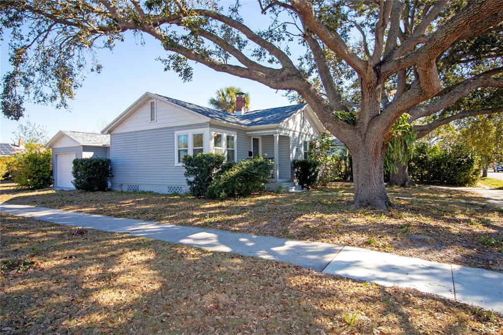 A light blue single-story house with a garage and a large tree in the yard — 1547 35TH AVENUE N, ST PETERSBURG, FL