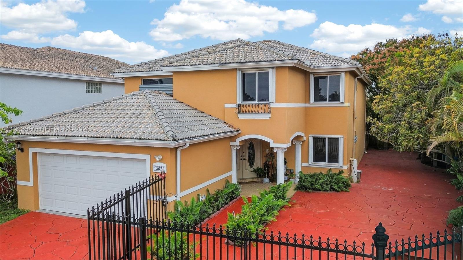 A two-story orange house with a tiled roof, garage, and red paved driveway — 15672 SW 91st Ln, Miami FL 33196, MIAMI, FL