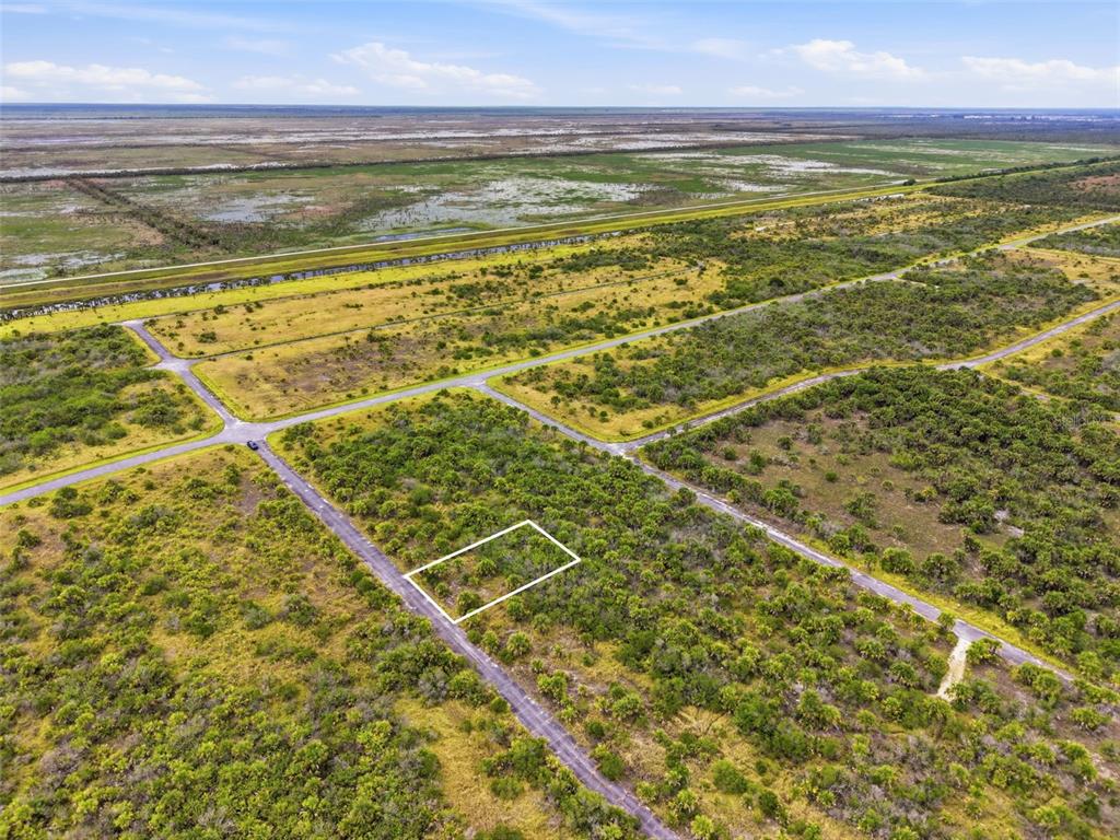 An aerial view shows a rectangular plot of land outlined in white within a rural area — 1553 ALCOVA STREET SW, PALM BAY, FL