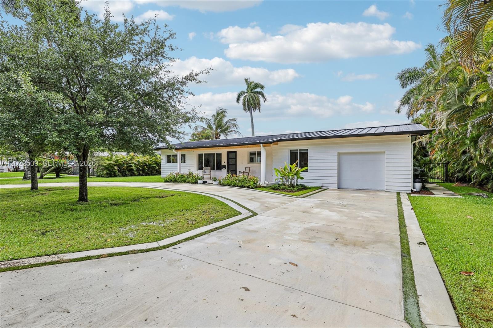 A single-story white house with a metal roof and a circular concrete driveway — 5620 SW 63rd Ct, South Miami FL 33143, SOUTH MIAMI, FL
