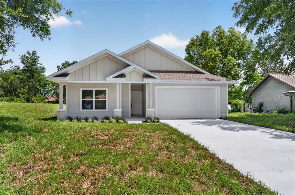 A single-story house with light-colored siding, a front porch, and an attached two-car garage — 631 S ANCHOR DRIVE, DELTONA, FL