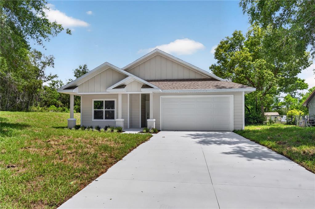 A single-story house with light-colored siding, a front-facing garage, and a concrete driveway — 631 S ANCHOR DRIVE, DELTONA, FL