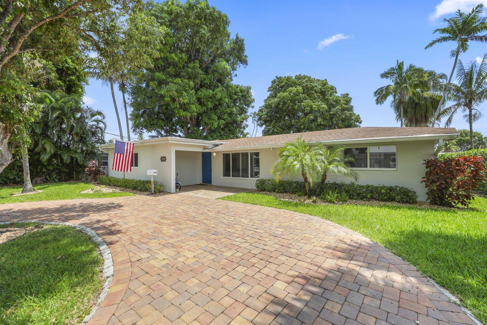 A single-story house with a brick paver driveway, a blue front door, and palm trees — 1710 SW 4th Avenue, Pompano Beach FL 33060, POMPANO BEACH, FL