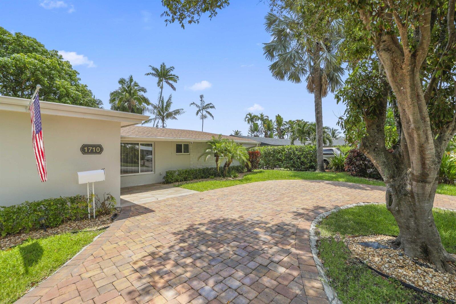 A paved driveway leads to the front entrance of a single-story house with palm trees — 1710 SW 4th Avenue, Pompano Beach FL 33060, POMPANO BEACH, FL