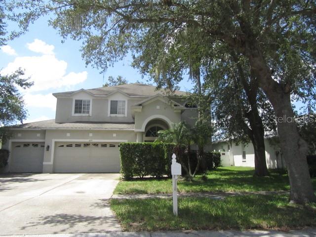 A two-story suburban house with a two-car garage and a large tree in the front yard — 4129 BALINGTON DRIVE, VALRICO, FL