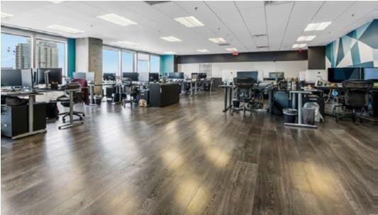 An open-plan office space features dark wood flooring, multiple workstations, and large windows with views — 121 S Orange Avenue # 1470N, FL 32801, FL